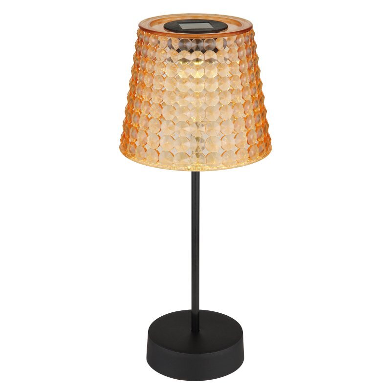 Lampa stołowa z czarną podstawą i pomarańczowym kloszem o fakturze przypominającej plaster miodu. Na górze klosza znajduje się panel solarny.
