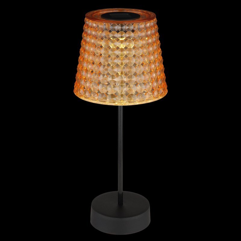 Lampa stołowa z czarną podstawą i trzonkiem, posiada klosz z przezroczystymi, fasetowanymi elementami, które emitują ciepłe światło. Klosz ma kształt stożka, a całość jest utrzymana w eleganckim stylu.