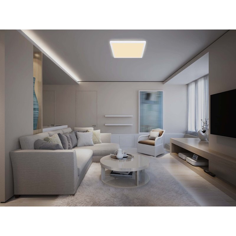 Nowoczesny salon z jasnym, prostokątnym plafonem LED na suficie. W pomieszczeniu znajduje się szara sofa, okrągły stolik kawowy i fotel, a na podłodze leży dywan.