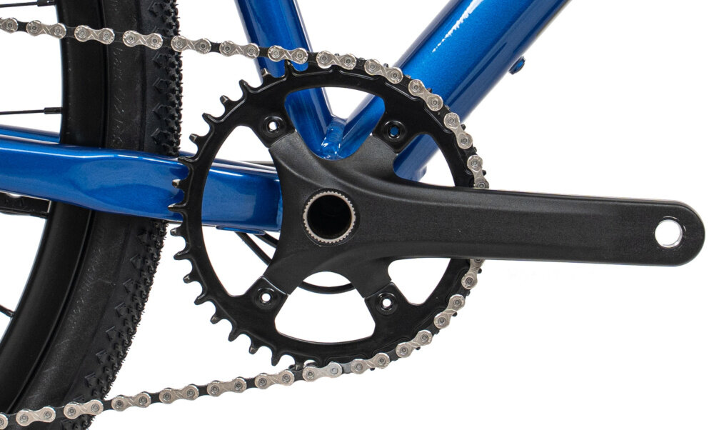 Rower gravel ROMET Aspre 2.1 2856M109-B U22 28 cali Niebieski zbliżenie na korbę i kasetę białe tło korba Prowheel RPL-FD16S z pojedynczą tarczą 40T kaseta MicroSHIFT Sword CS-104 o zakresie przełożeń 11–48T wkład suportu ROMET do jazdy po zróżnicowanych trasach dopasowanie kadencji do terenu solidny suport wspiera płynne przenoszenie mocy