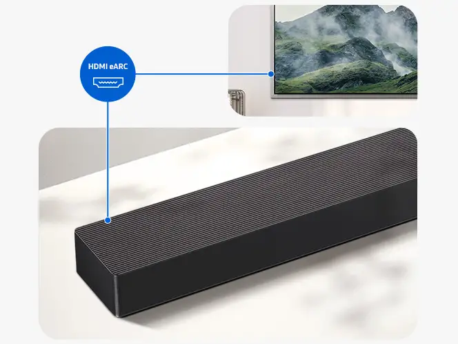 Grafitowo-czarny soundbar z widocznym oznaczeniem \'HDMI eARC\'. W tle fragment telewizora z wyświetlanym krajobrazem górskim.