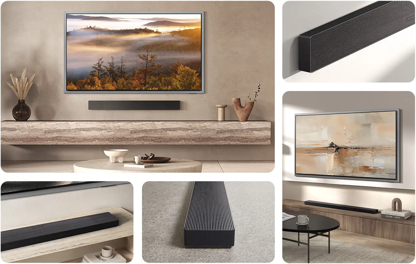 2026-hw-qs90h-lifestyle-gallery 1352x860 Na obrazku widać elegancko urządzony salon z telewizorem na ścianie i soundbarem umieszczonym pod nim. Soundbar jest grafitowo-czarny, a wnętrze jest utrzymane w stonowanych kolorach z elementami dekoracyjnymi na półkach.