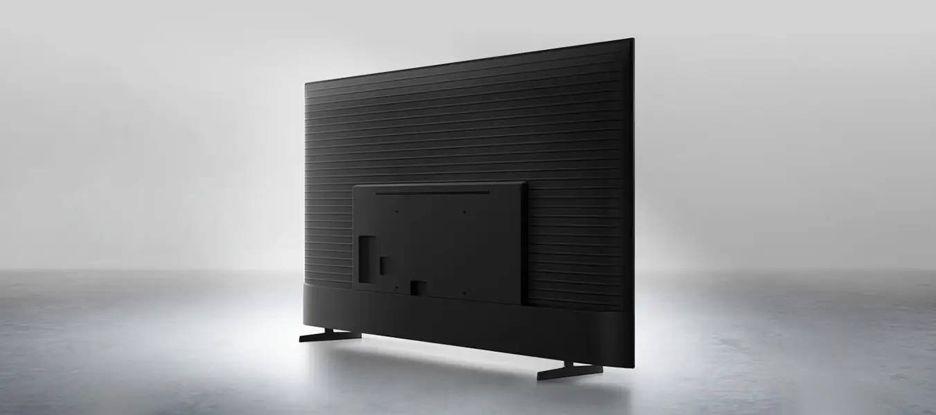 2026-metalstream-design-pc 1352x600 Obraz przedstawia tył czarnego telewizora z prostokątną podstawą i poziomymi liniami na obudowie. Telewizor stoi na jasnym tle.