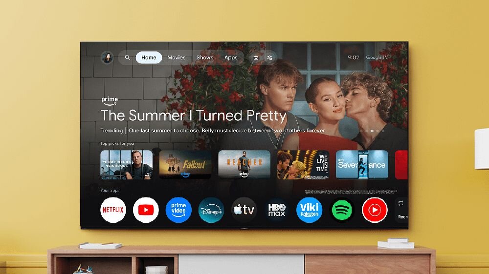Telewizor wyświetla ekran główny z aplikacjami streamingowymi, takimi jak Netflix, Prime Video, Disney+, Apple TV, HBO Max, Viki, Spotify i YouTube. Na ekranie widoczny jest także tytuł \'The Summer I Turned Pretty\'.