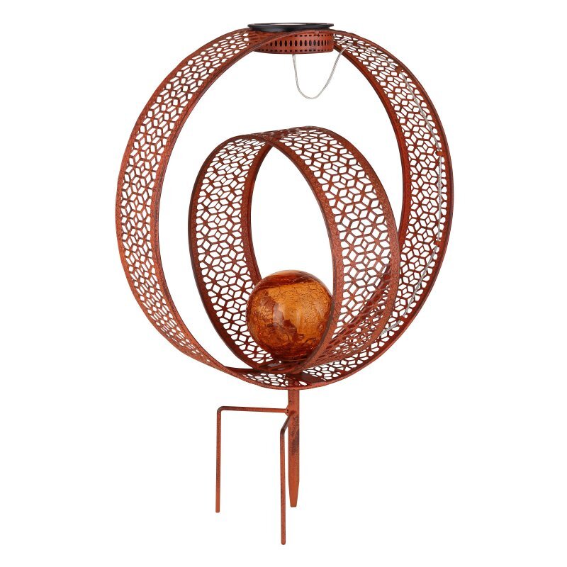 Dekoracyjna lampa solarna z metalu w kolorze miedzianym, z ażurowym wzorem i szklaną kulą w środku. Lampa posiada dwa metalowe pręty do wbicia w ziemię.