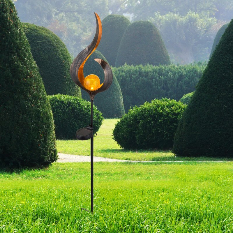 Lampa solarna LED o dekoracyjnym kształcie z kulą świetlną, umieszczona na tle zielonego ogrodu z przyciętymi krzewami.