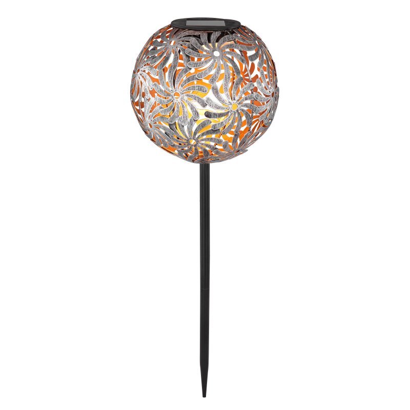 Lampa solarna LED z dekoracyjnym kloszem o ażurowym wzorze, zamontowana na długim, czarnym pręcie. Klosz emituje ciepłe światło, tworząc wzory świetlne.
