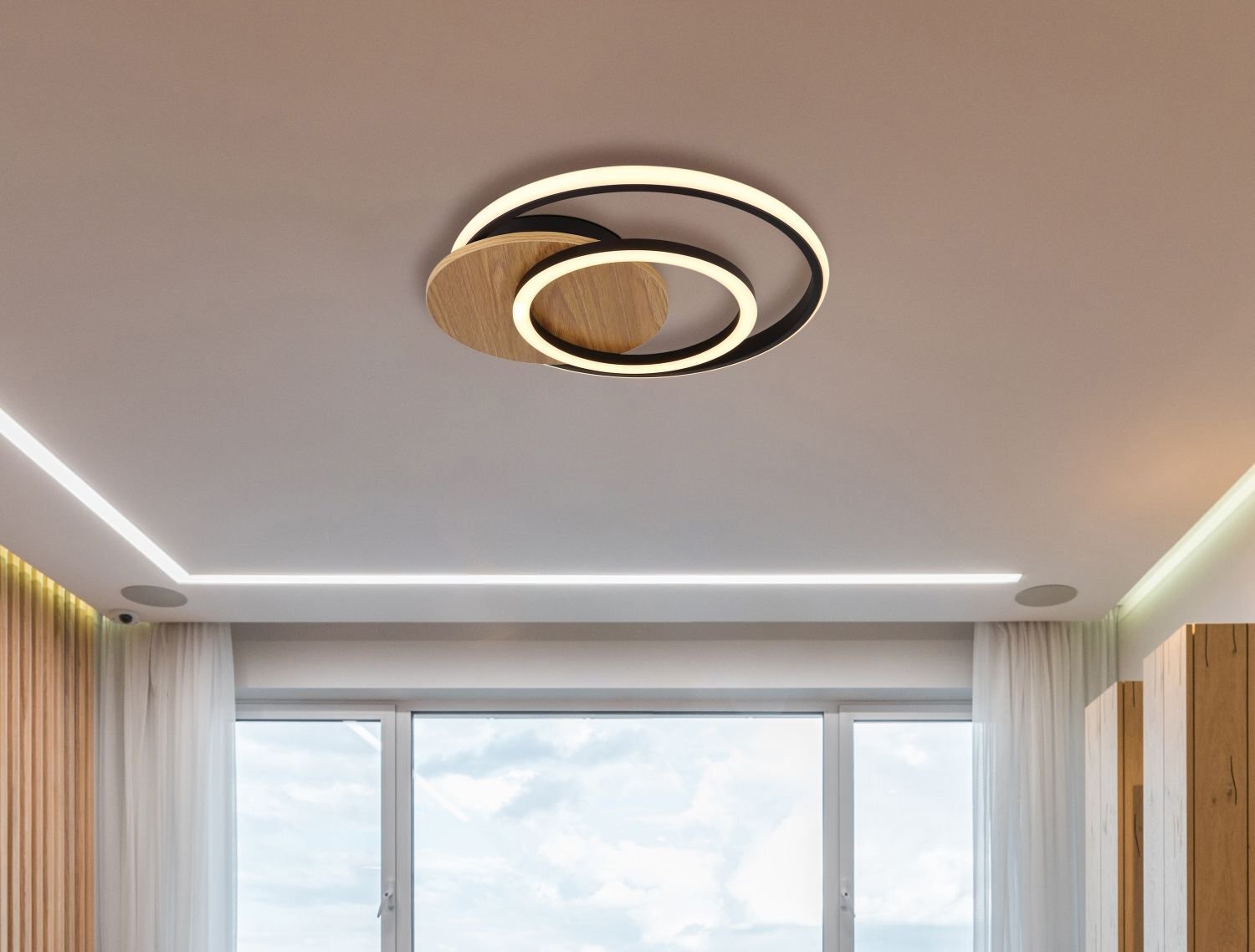 Na suficie znajduje się nowoczesna lampa sufitowa LED o geometrycznym kształcie z drewnianymi i czarnymi elementami. W tle widoczne jest okno z zasłonami i fragmenty ścian z drewnianymi panelami.