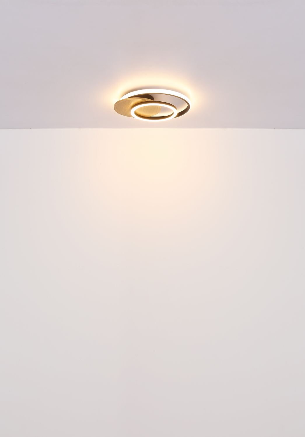 Na obrazie widoczna jest nowoczesna lampa sufitowa LED emitująca ciepłe światło, zamontowana na białym suficie.