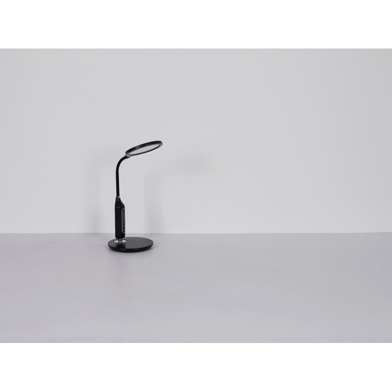 Czarna lampa biurkowa LED z okrągłą podstawą i elastycznym ramieniem, zakończona okrągłym kloszem. Lampa stoi na jasnym tle.