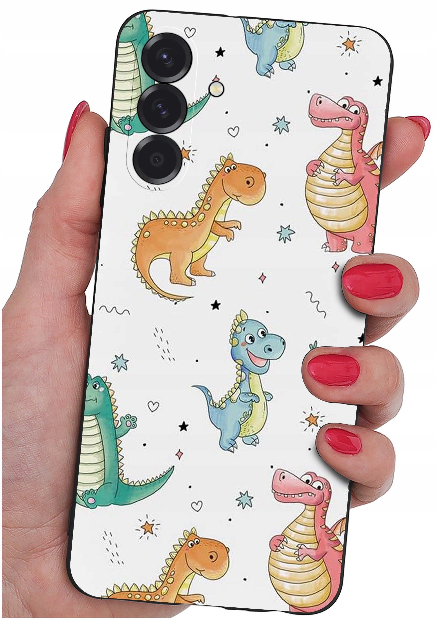 Etui na telefon z kolorowym wzorem dinozaurów trzymane w dłoni z pomalowanymi na czerwono paznokciami. Etui ma trzy otwory na aparaty fotograficzne.