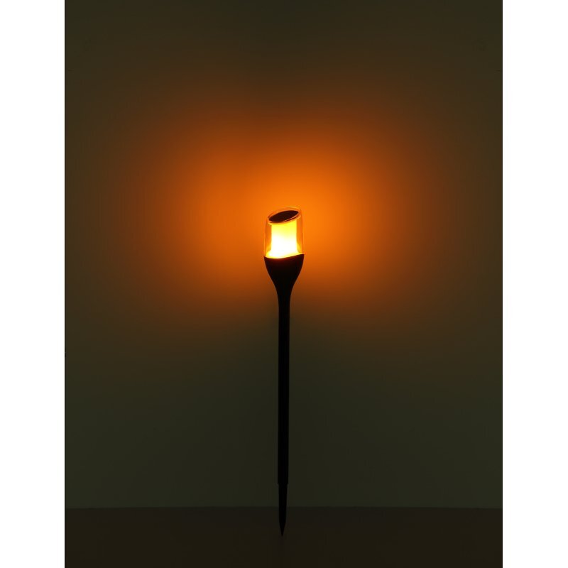 Lampa solarna dogruntowa LED emituje ciepłe, pomarańczowe światło, zamontowana na długim, czarnym trzonku.