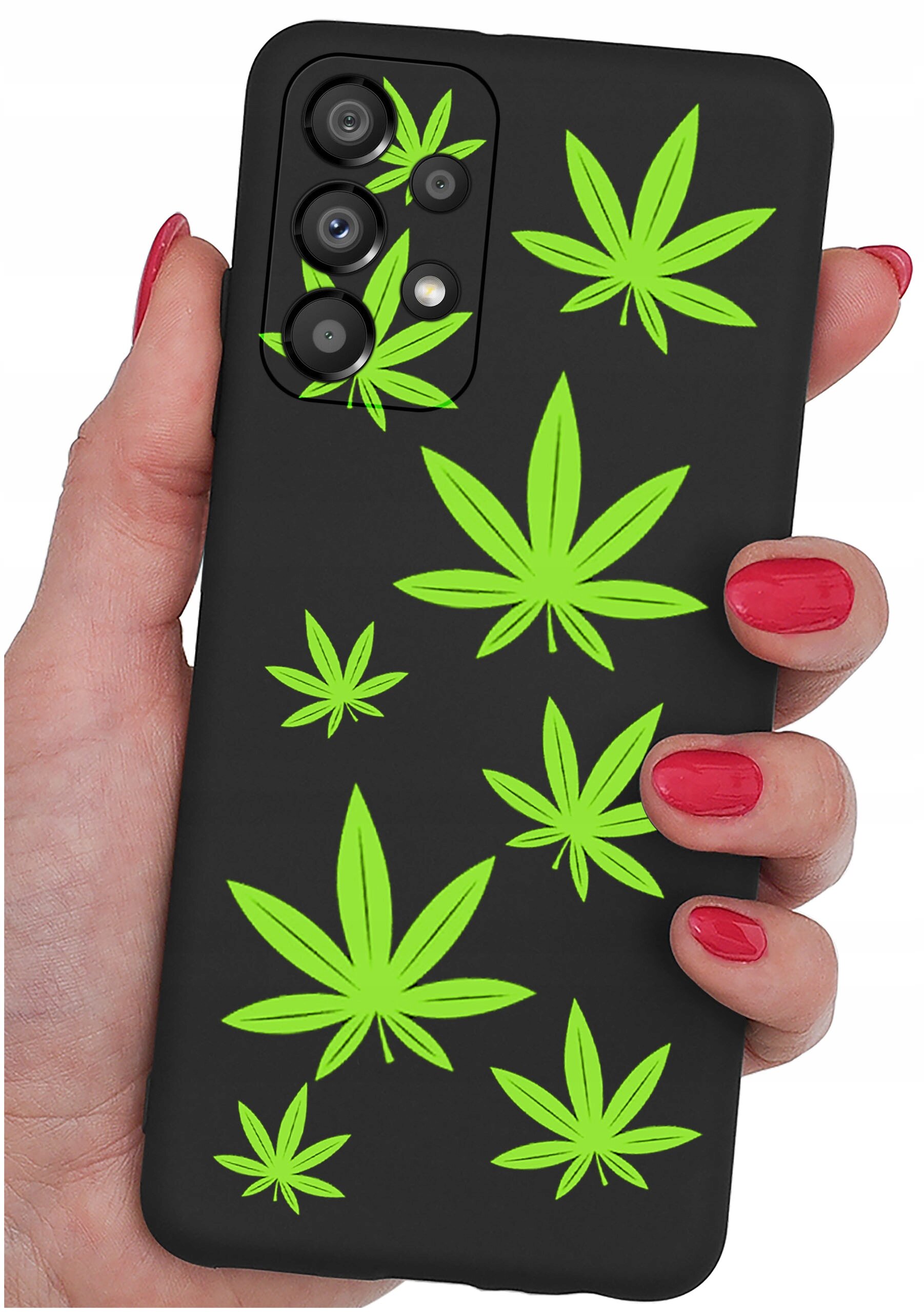 Czarne etui na telefon z zielonymi wzorami liści, trzymane w dłoni z pomalowanymi na czerwono paznokciami.