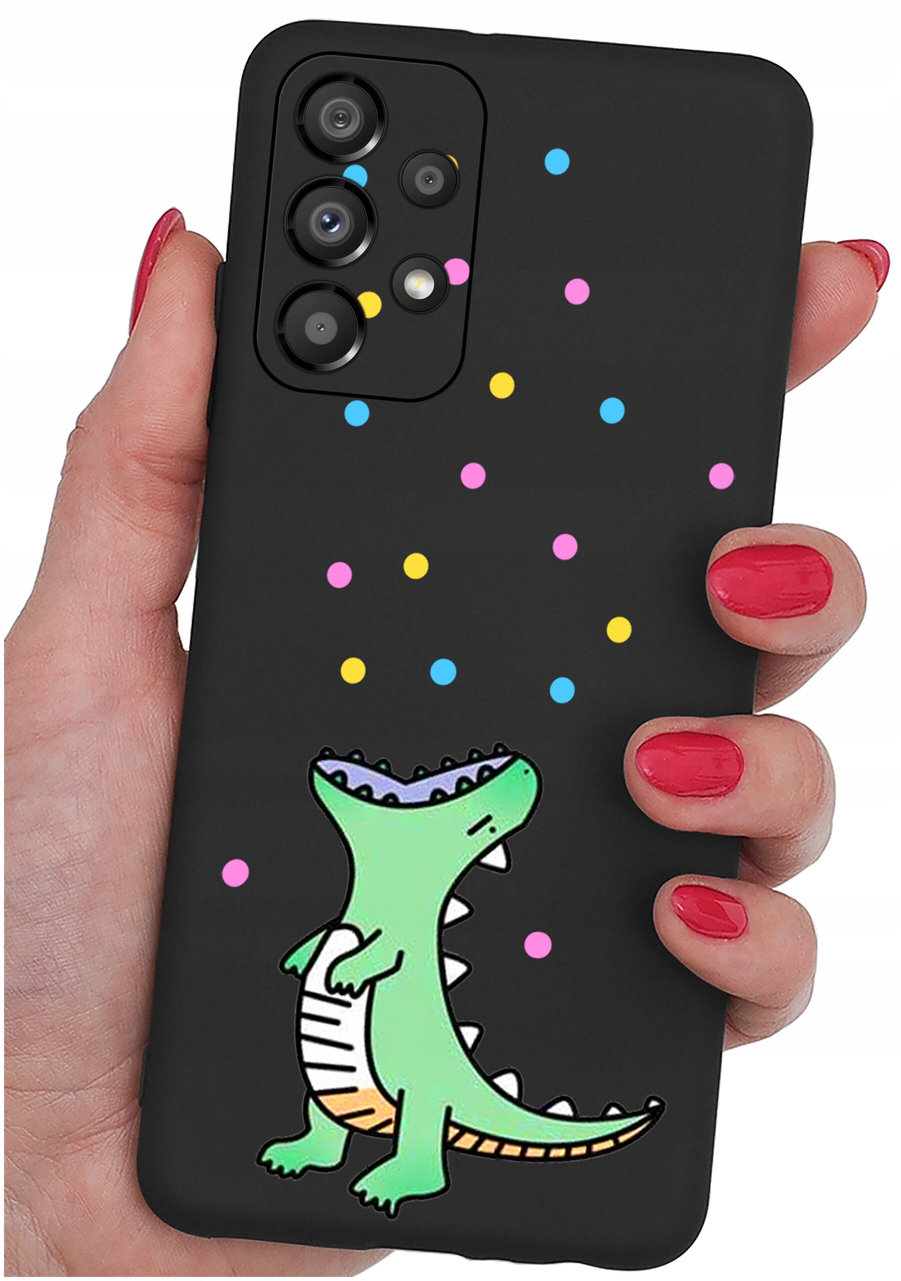 Czarne etui na telefon z kolorowym wzorem przedstawiającym zielonego dinozaura i kolorowe kropki. Etui jest trzymane w dłoni z pomalowanymi na czerwono paznokciami.