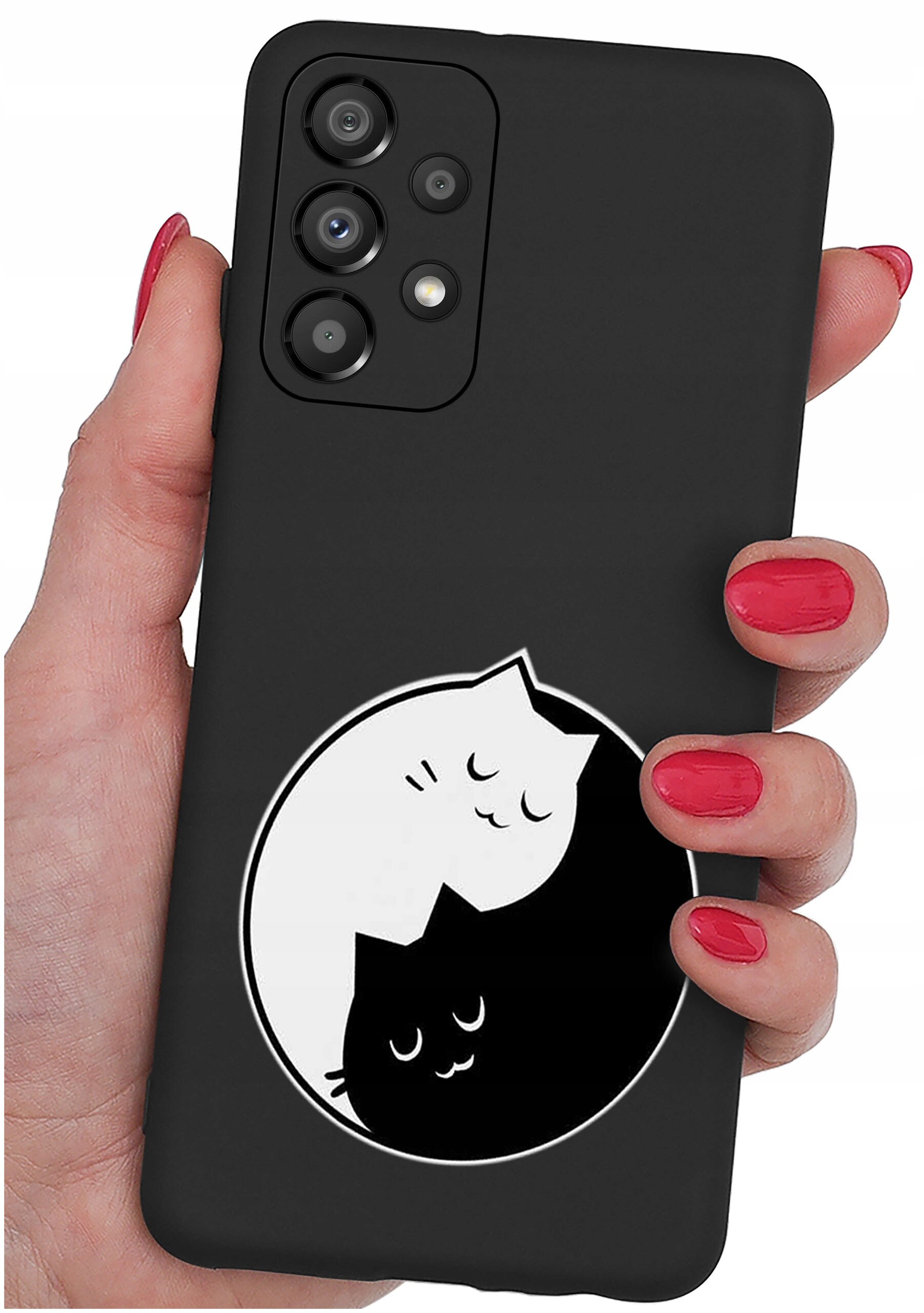 Czarne etui na telefon z grafiką dwóch kotów w stylu yin-yang, trzymane w dłoni z pomalowanymi na czerwono paznokciami.