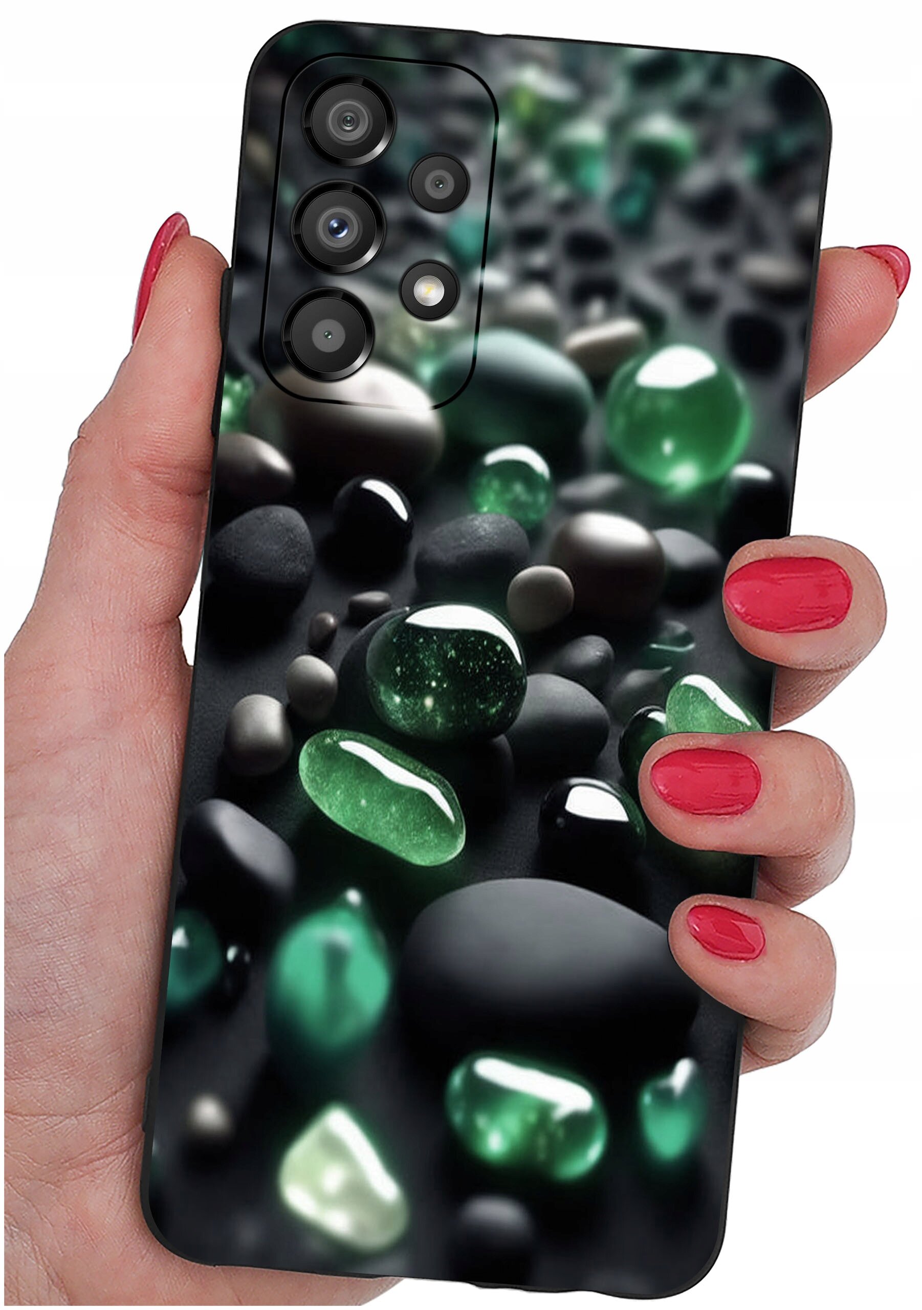 Osoba trzyma telefon z etui ozdobionym wzorem zielonych i czarnych kamieni. Etui jest silikonowe, a na zdjęciu widoczne są cztery obiektywy aparatu.