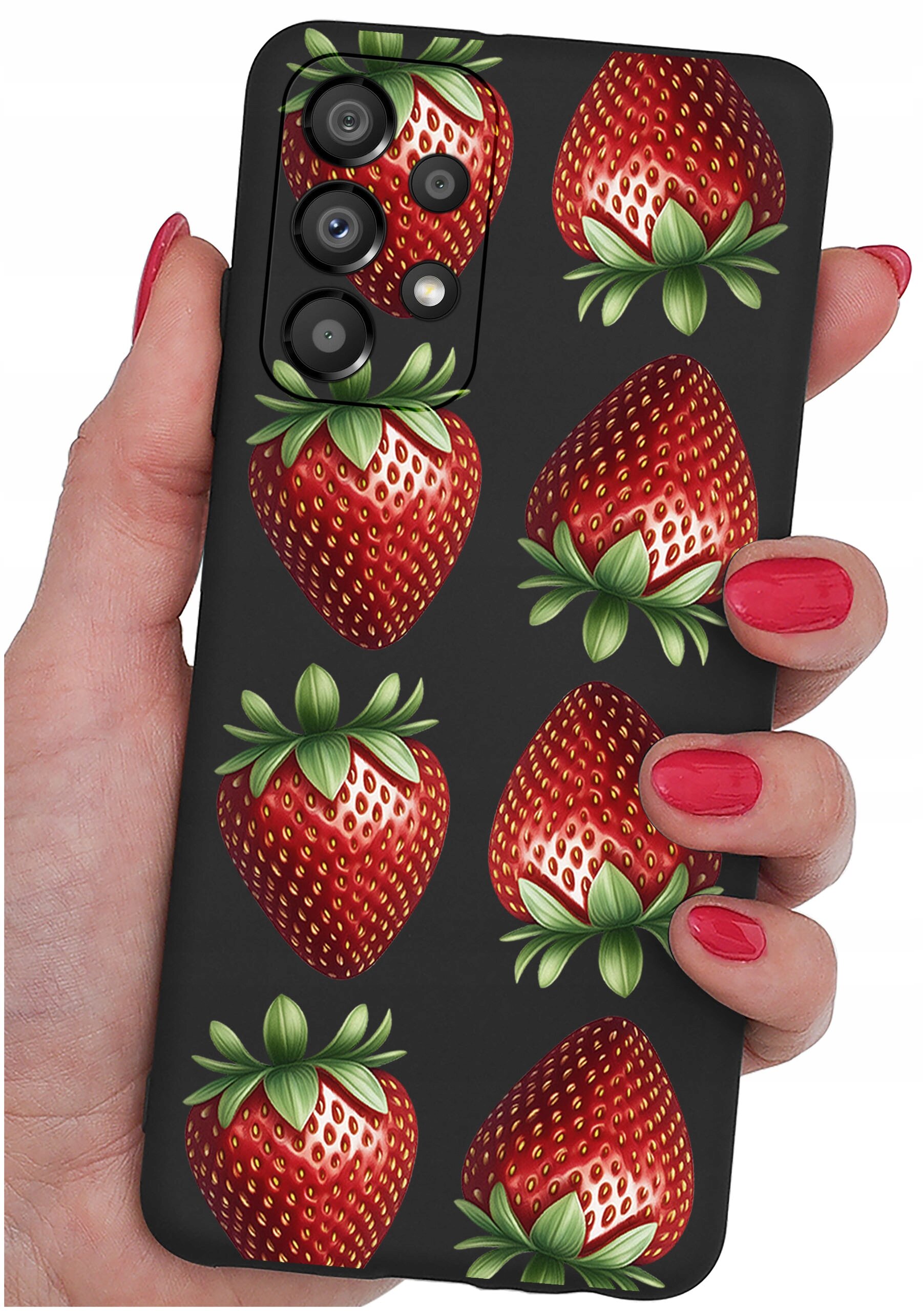 Etui na telefon z wzorem truskawek, trzymane w dłoni z pomalowanymi na czerwono paznokciami. Etui ma czarne tło i wycięcia na aparat.