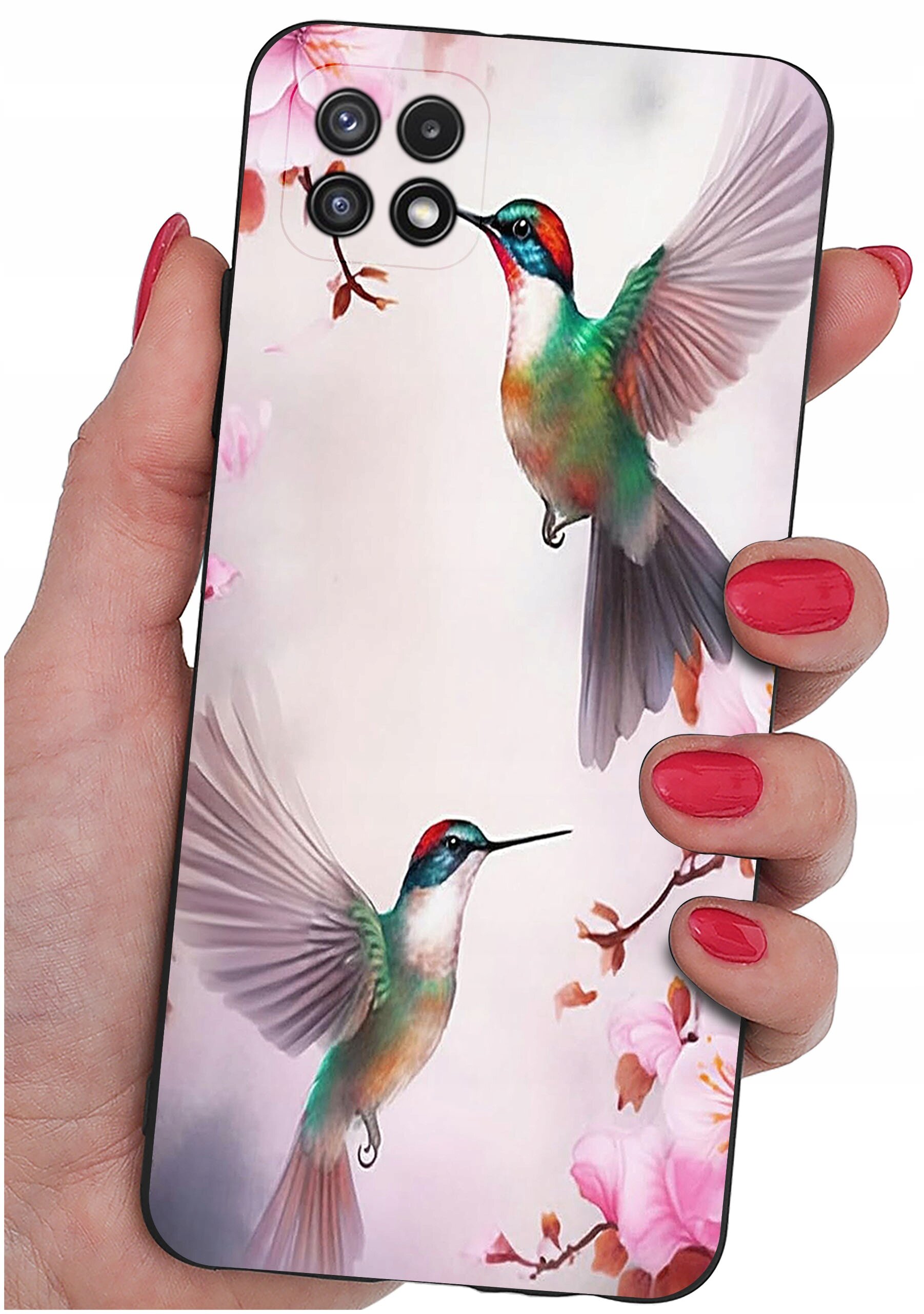 Etui na telefon z kolorowym wzorem przedstawiającym dwa kolibry wśród różowych kwiatów. Etui trzymane jest w dłoni z pomalowanymi na czerwono paznokciami.