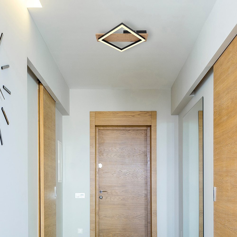 Wnętrze korytarza z drewnianymi drzwiami i lustrzaną szafą, na suficie zamontowana jest kwadratowa lampa sufitowa z czarnym matowym wykończeniem i ciemnym drewnem. Na ścianie widoczny jest nowoczesny zegar bez cyfr.