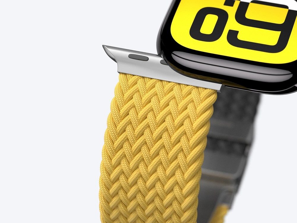 Zbliżenie na splecioną tkaninę żółtego paska AmazingThing Blend Band przy złączeniu z kopertą Apple Watch, widok pod kątem, jasne tło.