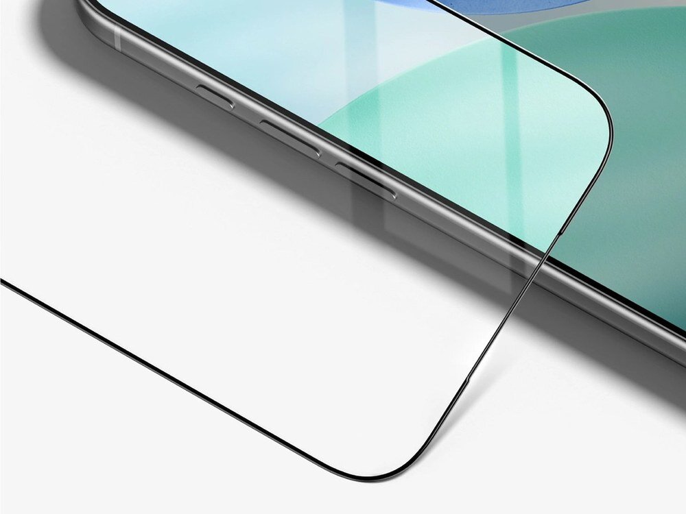 Zbliżenie na krawędź szkła hartowanego z czarną ramką leżącego obok rogu iPhone'a, widok pod kątem na białym tle.