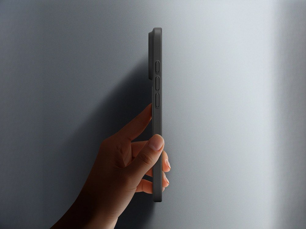 Czarne etui AmazingThing Minimal Air na iPhone 17 Pro trzymane w dłoni, widok boczny ukazujący wyjątkową smukłość obudowy na szarym tle.