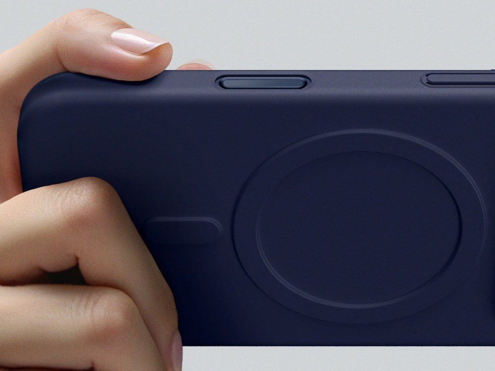 Osoba trzyma niebieskie etui na telefon z widocznym okrągłym wzorem na powierzchni. Etui posiada wycięcia na przyciski boczne.