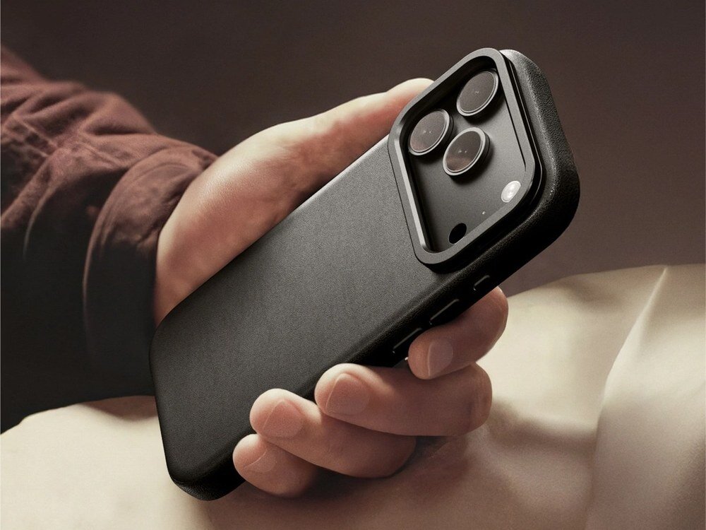 Czarne etui AmazingThing Glamour na iPhone 17 Pro Max trzymane w dłoni, widok z tyłu z modułem aparatu, ciepłe tło.