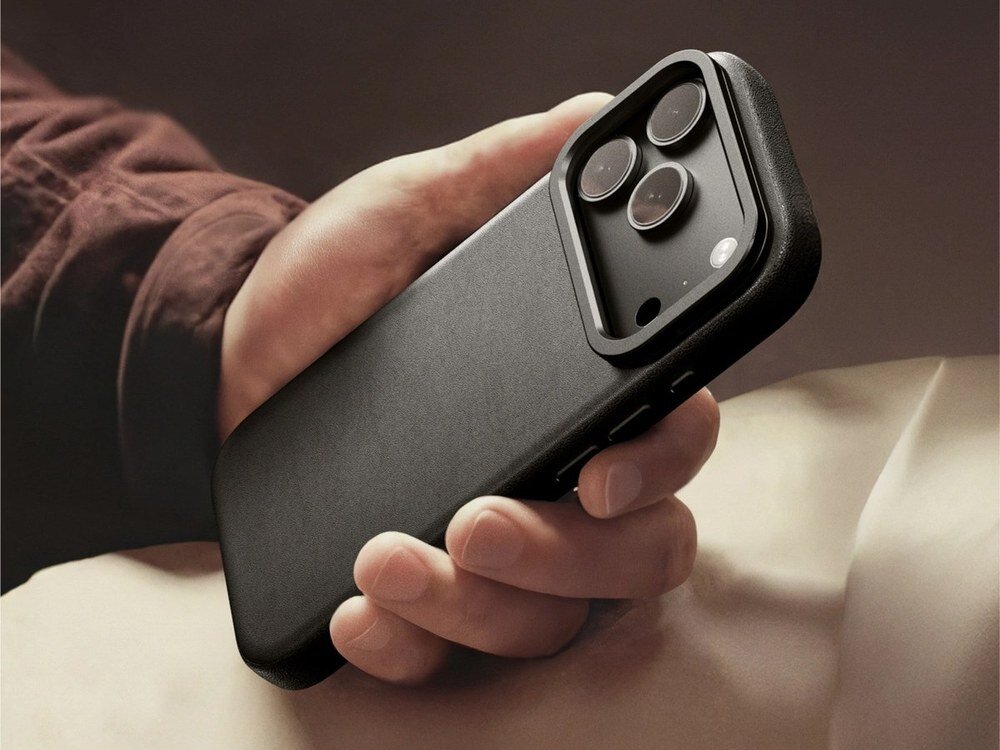 Czarne etui AmazingThing Glamour na iPhone 17 Pro trzymane w dłoni, widok tylnej części z modułem aparatu, ciemne tło.