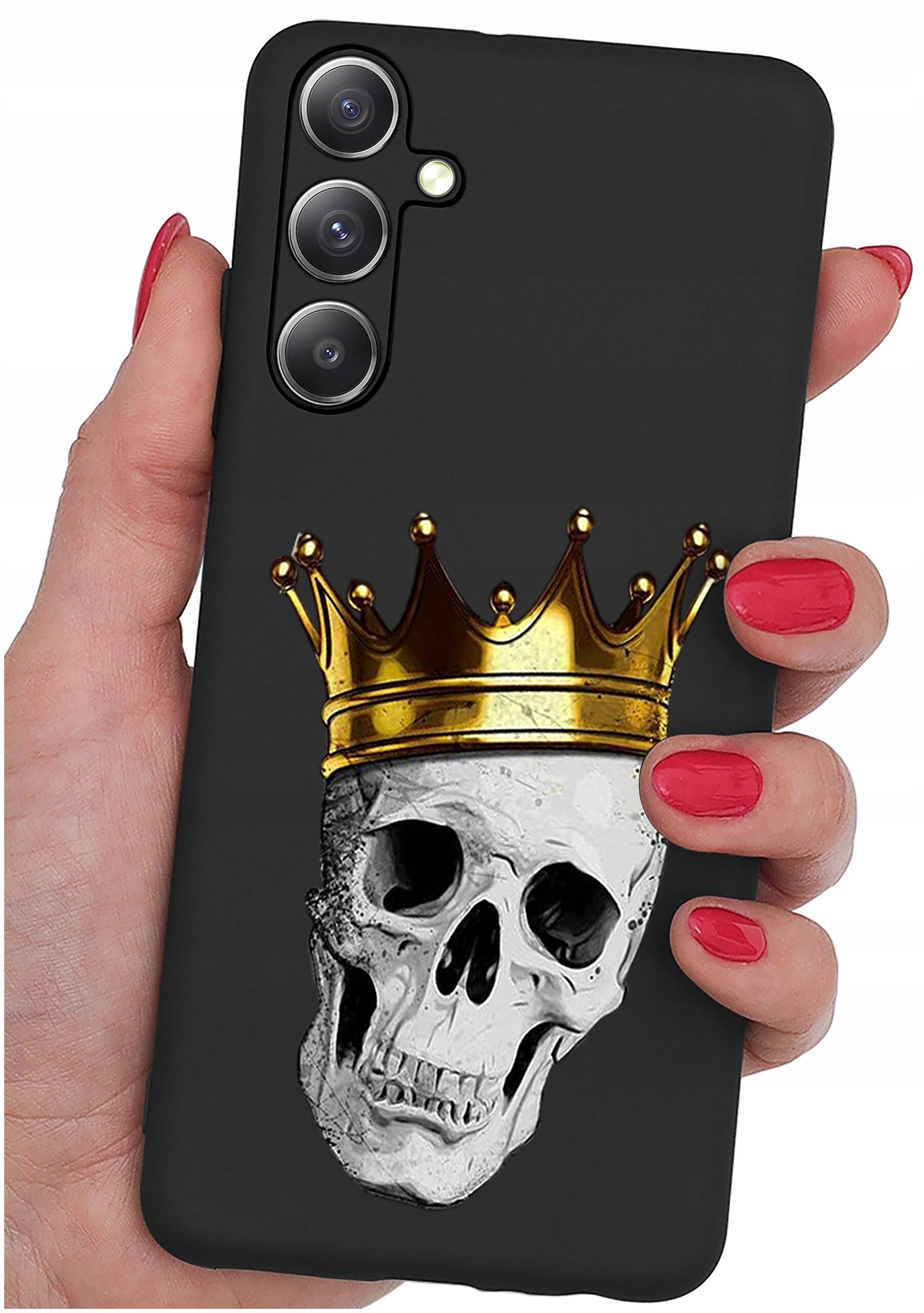 Czarna obudowa telefonu z nadrukiem czaszki w złotej koronie, trzymana w dłoni z czerwonymi paznokciami. Widoczne są trzy obiektywy aparatu na górze obudowy.