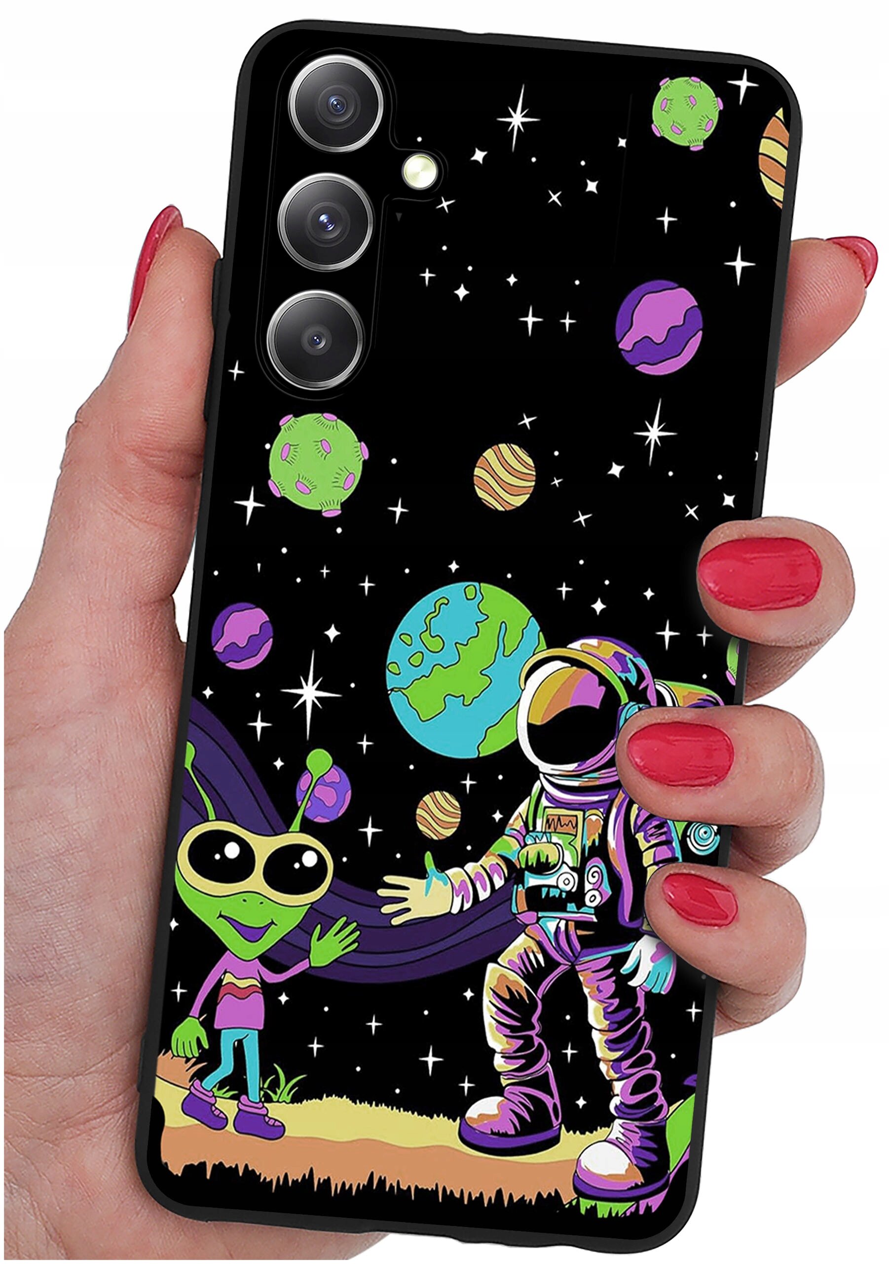 Etui na telefon z kolorowym wzorem przedstawiającym kosmonautę i zielonego kosmitę na tle kosmosu z planetami i gwiazdami. Etui trzymane jest w dłoni z pomalowanymi na czerwono paznokciami.