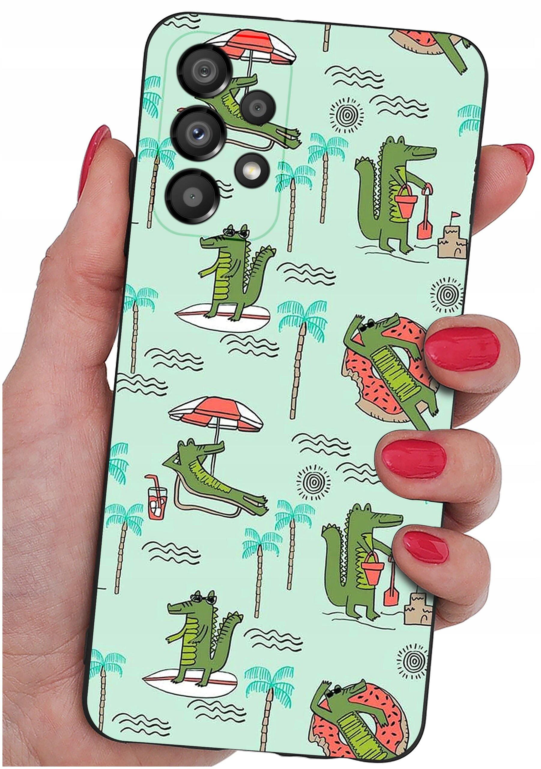 Etui na telefon z wzorem przedstawiającym zielone krokodyle w różnych wakacyjnych scenach, takich jak leżenie na leżaku czy budowanie zamku z piasku. Etui trzymane jest w dłoni z pomalowanymi na czerwono paznokciami.