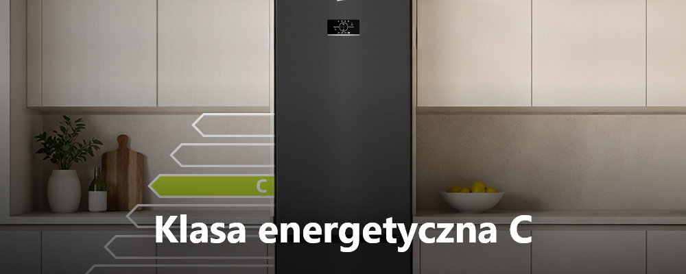 Ciemna lodówka stoi w kuchni z jasnymi szafkami. Na obrazie widoczny jest tekst: \'Klasa energetyczna C\'.