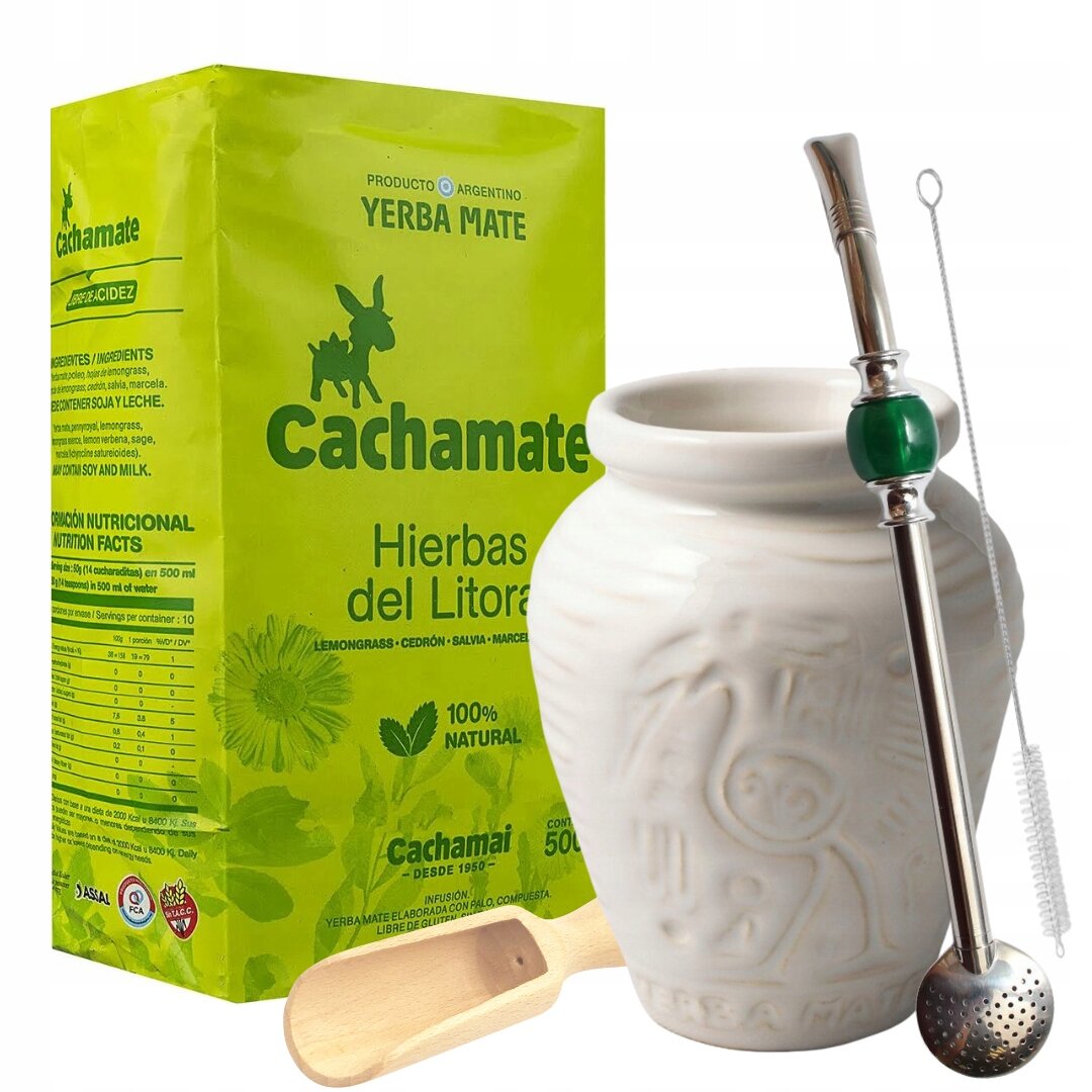 Na obrazie znajduje się zielone opakowanie Yerba Mate Cachamate Hierbas del Litoral oraz biały ceramiczny kubek z metalową bombillą i drewnianą nabierką. Opakowanie zawiera napisy: \'Cachamate\', \'Hierbas del Litoral\', \'100% Natural\'.