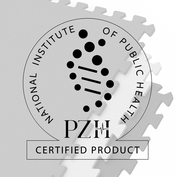 Na obrazie widoczna jest mata puzzle z czarnymi elementami, na której znajduje się okrągłe logo z napisem \'NATIONAL INSTITUTE OF PUBLIC HEALTH PZH CERTIFIED PRODUCT\'.