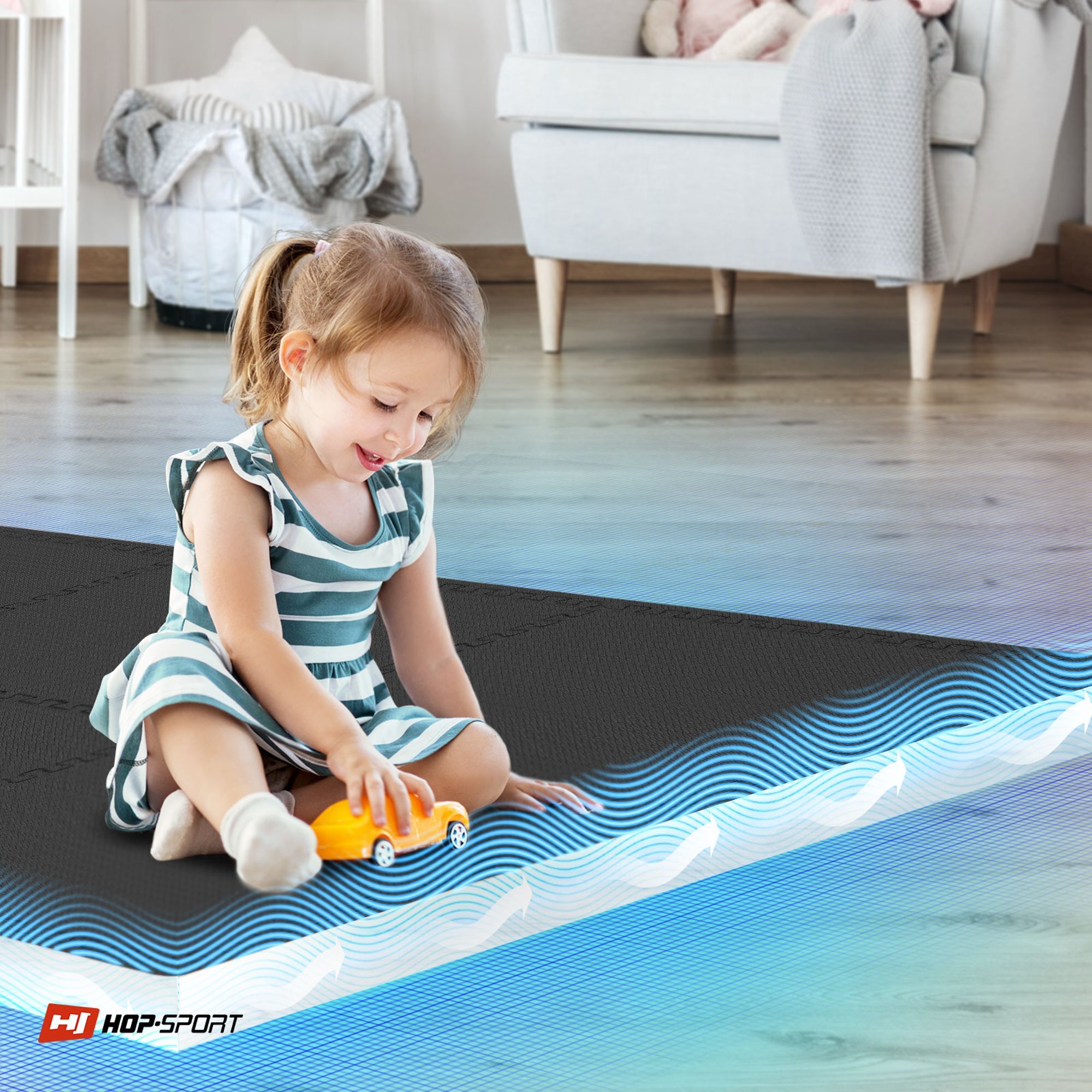 Dziecko bawi się żółtym samochodzikiem na czarnej macie puzzle EVA. W rogu widoczne jest logo \'HOP-SPORT\'.