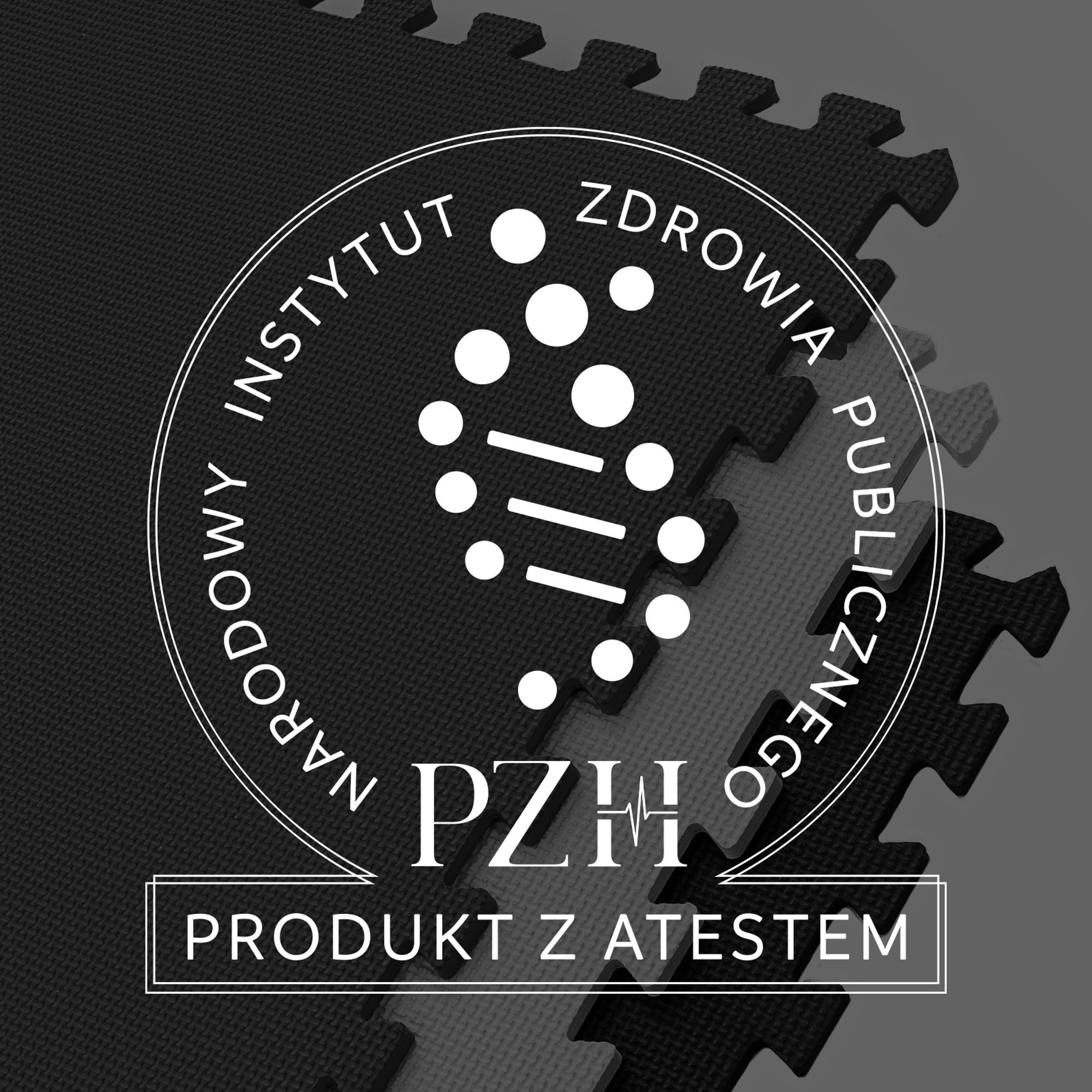 Na obrazie widoczna jest mata puzzle w kolorze szarym z teksturą, z logo Narodowego Instytutu Zdrowia Publicznego oraz napisem \'PZH PRODUKT Z ATESTEM\'.
