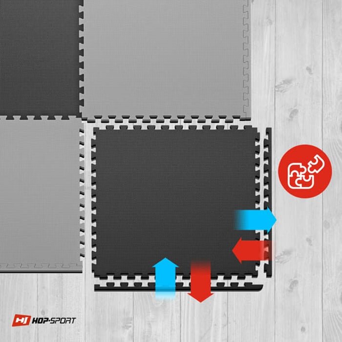 Obraz przedstawia czarno-szare maty puzzle EVA ułożone na drewnianej podłodze. W prawym dolnym rogu znajduje się logo \'HOP-SPORT\' oraz czerwone koło z białym symbolem puzzli.