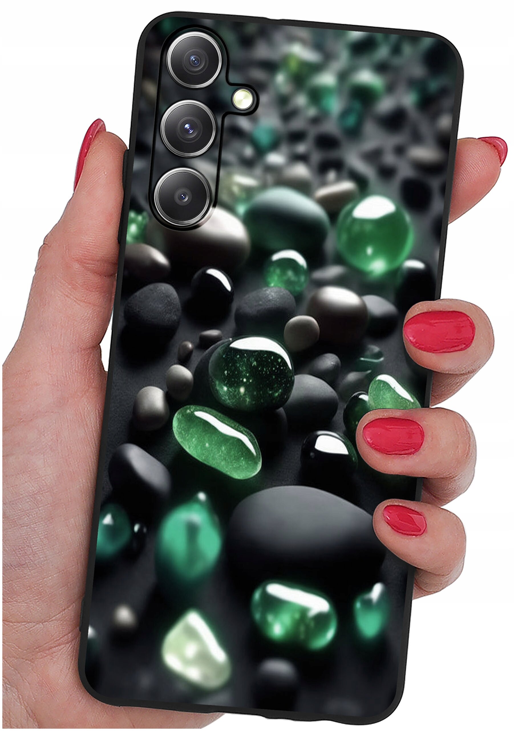 Osoba trzyma telefon z etui ozdobionym wzorem przedstawiającym zielone i czarne kamienie. Etui ma wycięcia na trzy obiektywy aparatu i lampę błyskową.