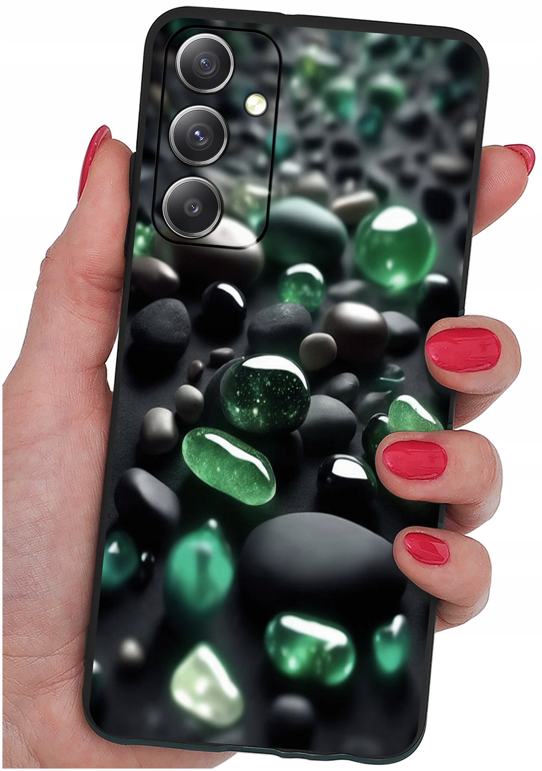 Osoba trzyma telefon z etui ozdobionym wzorem zielonych i czarnych kamieni. Etui ma wycięcia na trzy obiektywy aparatu i lampę błyskową.