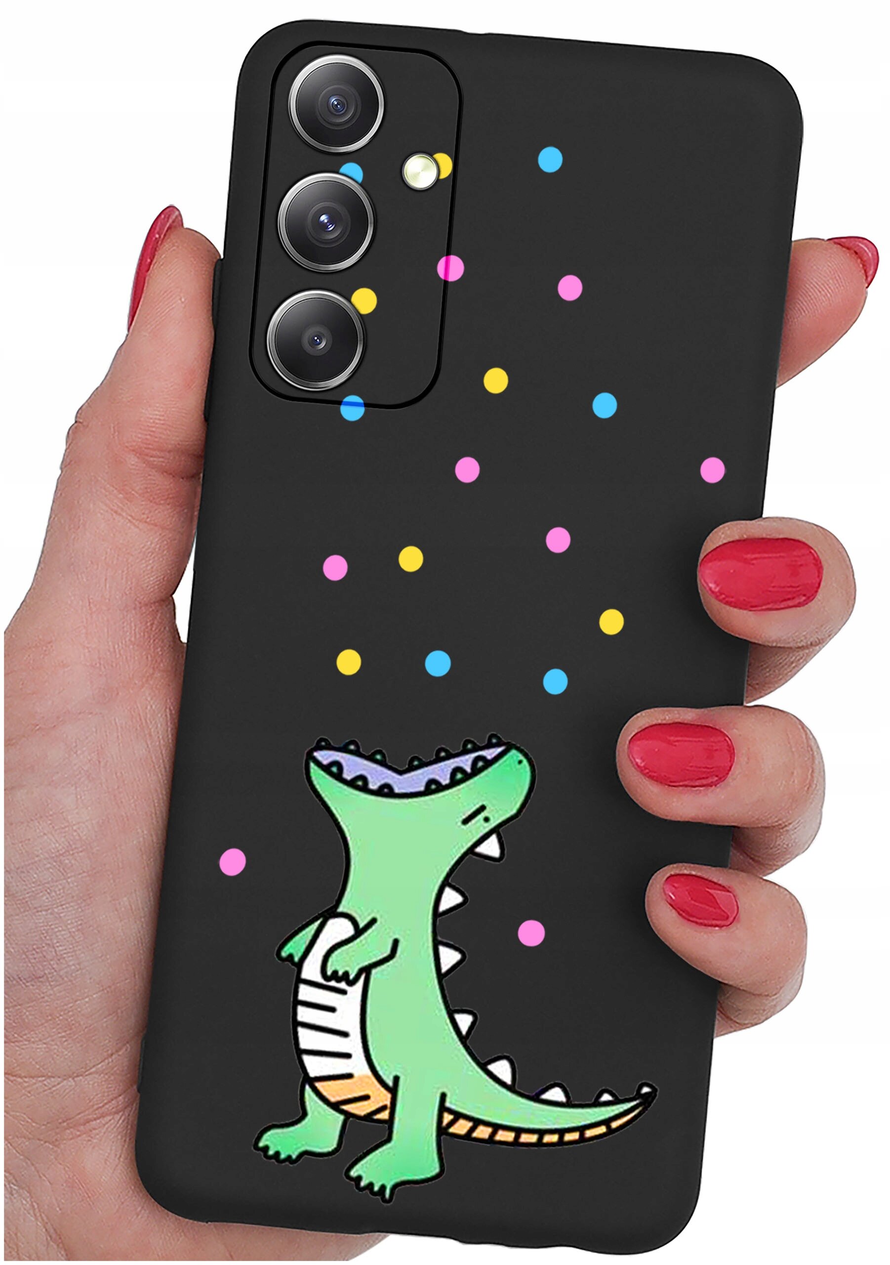 Czarne etui na telefon z kolorowym wzorem przedstawiającym zielonego dinozaura i kolorowe kropki. Etui jest trzymane w dłoni z pomalowanymi na czerwono paznokciami.