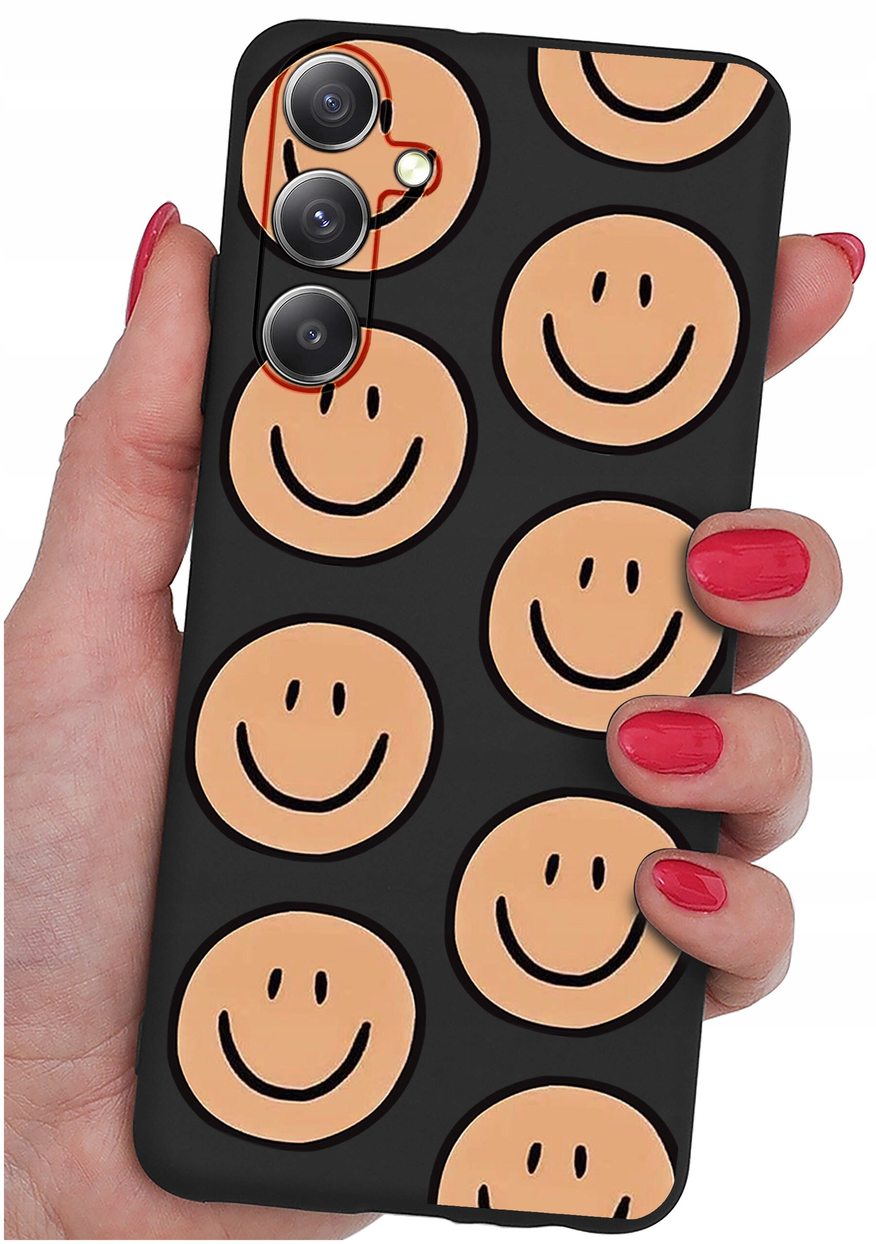 Osoba trzyma telefon w etui z czarnym tłem i wzorem beżowych uśmiechniętych buziek. Etui ma wycięcia na trzy obiektywy aparatu.