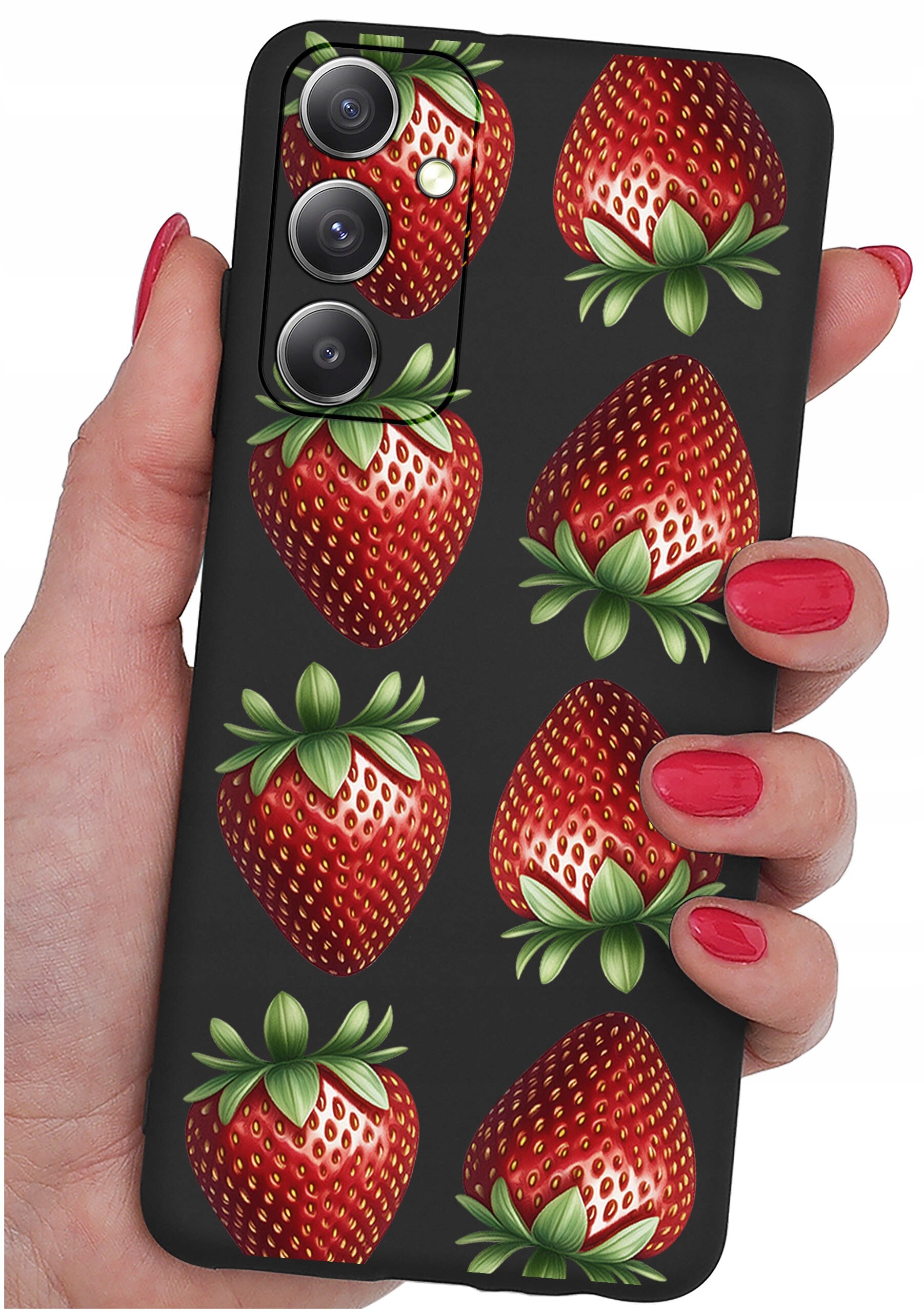 Etui na telefon z wzorem truskawek, trzymane w dłoni z pomalowanymi na czerwono paznokciami. Etui ma trzy otwory na aparaty fotograficzne.