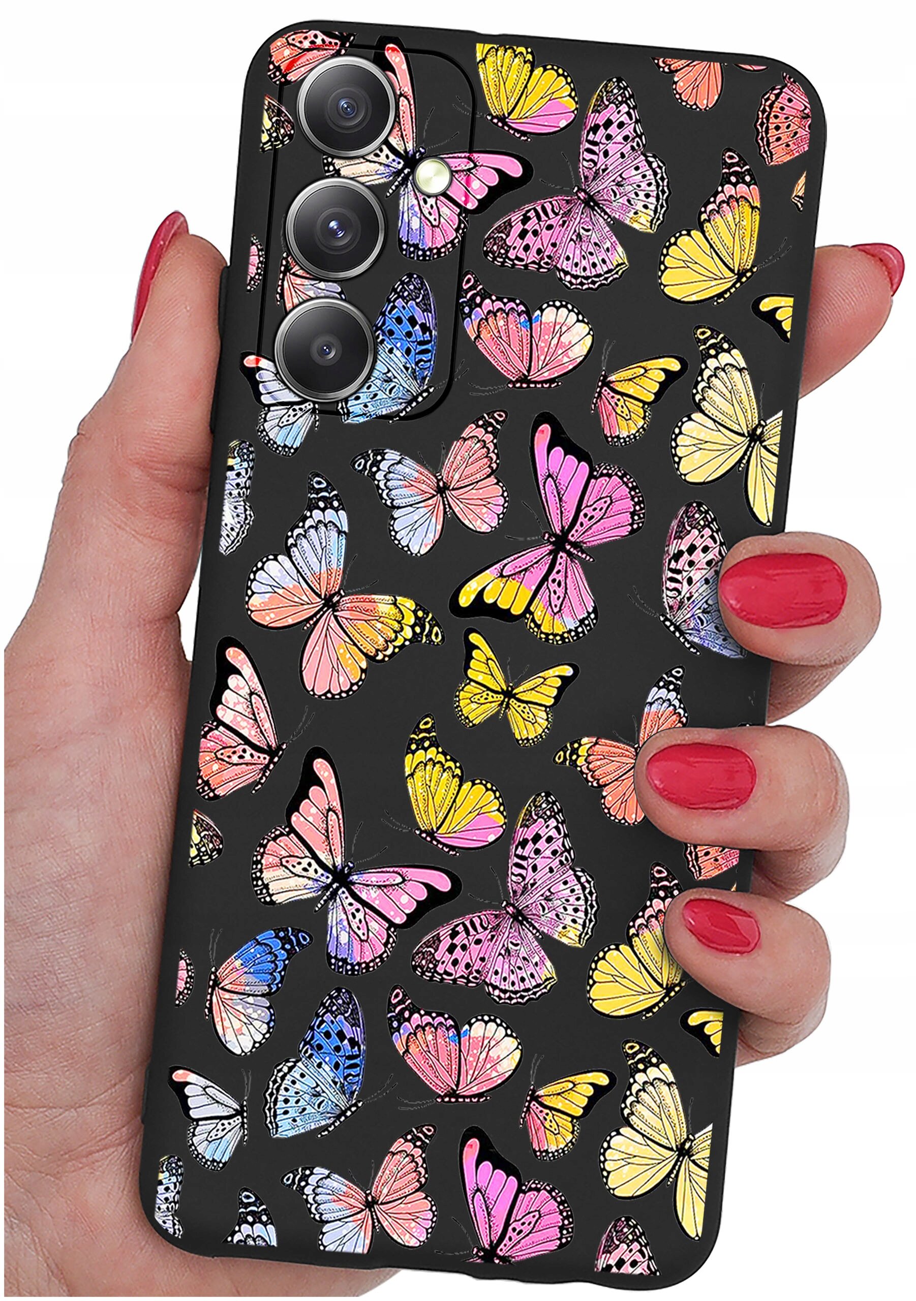 Etui na telefon z kolorowym wzorem motyli trzymane w dłoni z pomalowanymi na czerwono paznokciami. Etui ma czarne tło i wycięcia na trzy obiektywy aparatu.