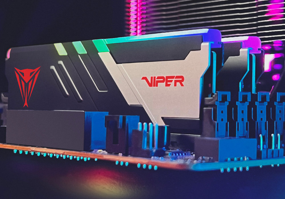 Na obrazie widoczna jest pamięć RAM z podświetleniem RGB, z logo \'Viper\' i czerwonym symbolem. Moduły są zamontowane na płycie głównej, a w tle widać kolorowe światła.