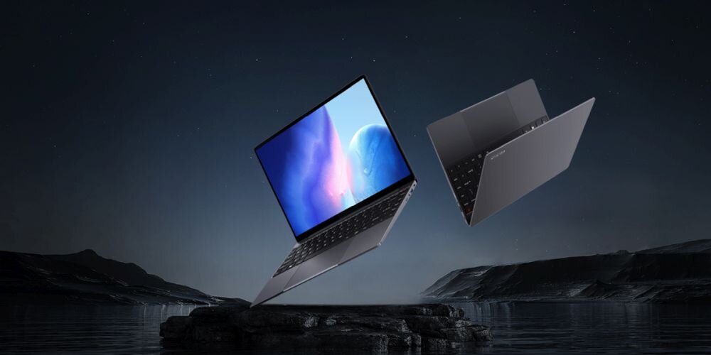 Dwa srebrne laptopy unoszą się nad skalistym krajobrazem pod nocnym niebem