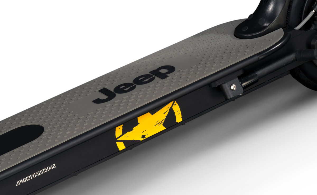 Na obrazie widoczna jest część hulajnogi elektrycznej z szarą platformą, na której znajduje się napis \'Jeep\'. Na boku widoczny jest żółty symbol oraz numer \'JPMY2205005048\'.