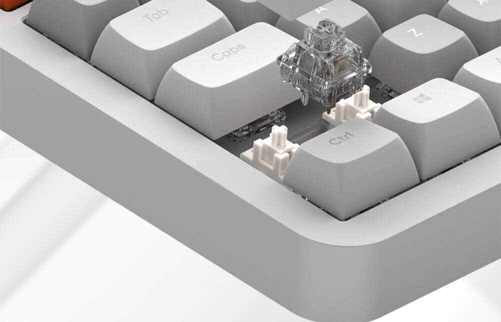 Zbliżenie na klawiaturę z białymi klawiszami, z widocznym przełącznikiem mechanicznym pod klawiszem \'Ctrl\'. Widoczne klawisze to \'Tab\', \'Caps\', \'Ctrl\' oraz klawisz z logo Windows.