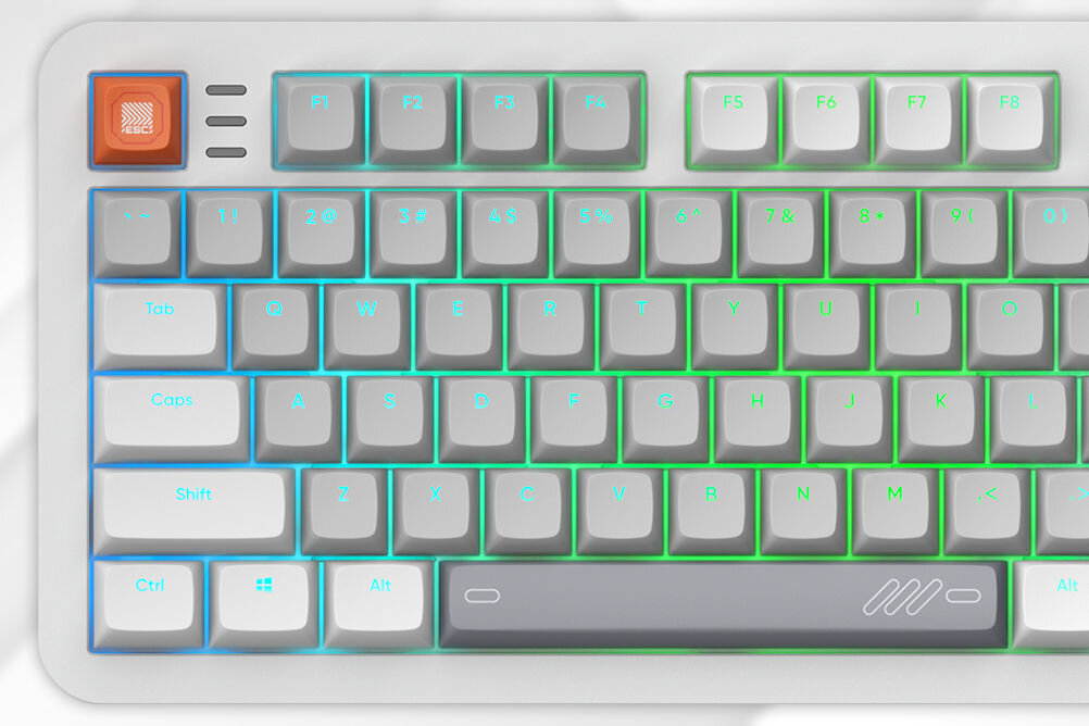 Klawiatura mechaniczna z podświetleniem RGB, posiada klawisze funkcyjne F1-F8 oraz klawisze alfanumeryczne. Jeden z klawiszy jest pomarańczowy z białym wzorem, a spacja ma szary kolor z białym symbolem.