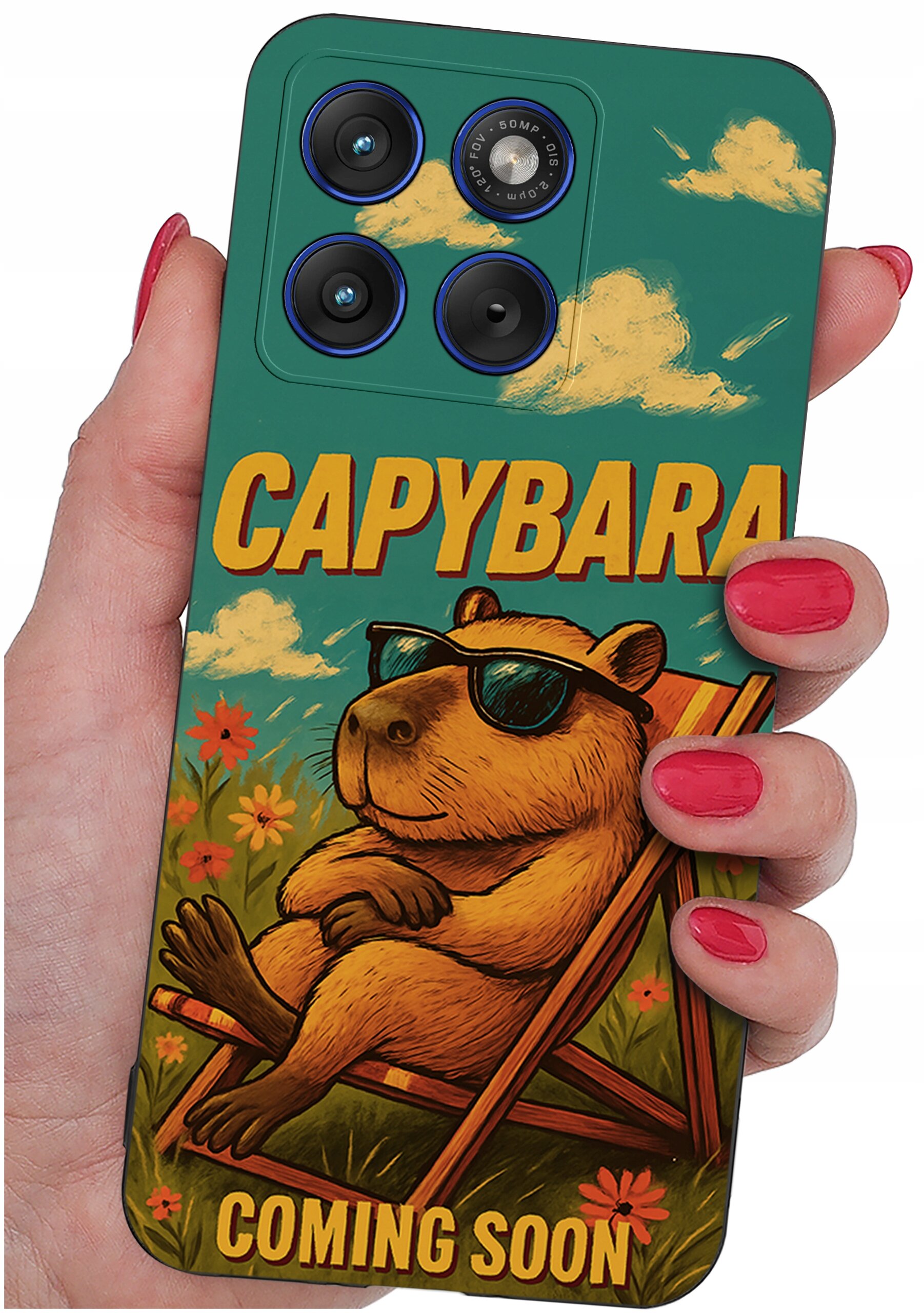 Etui na telefon z grafiką kapibary w okularach przeciwsłonecznych, siedzącej na leżaku, z napisem \'CAPYBARA COMING SOON\'. Etui trzymane jest w dłoni z pomalowanymi na czerwono paznokciami.